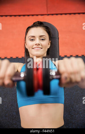 L'accent woman lifting dumbbells en position couchée Banque D'Images