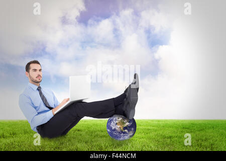 Image composite de businessman using laptop Banque D'Images