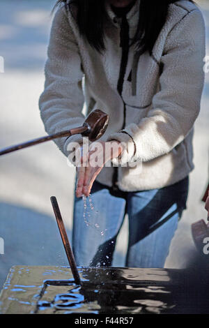 Le nettoyage des mains dans l'eau dans le Shinto shrine temple bouddhiste Banque D'Images