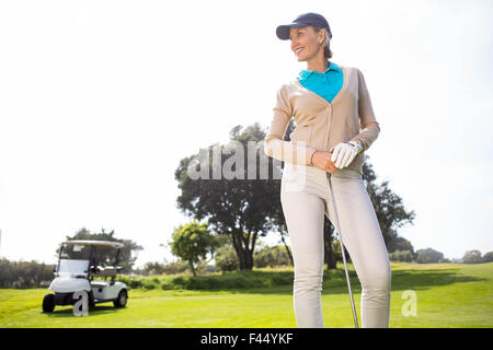 Golfeur féminin souriant et posant Banque D'Images