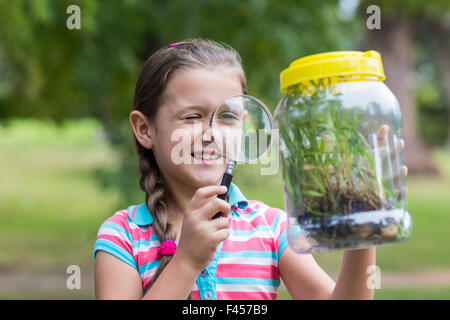 Curieux petit girl looking at jar Banque D'Images