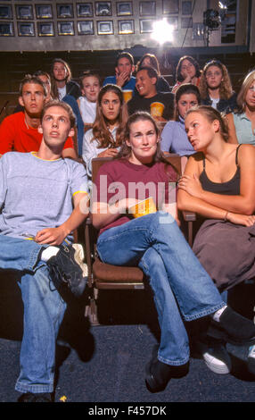 Montrant diverses émotions, un groupe d'élèves du secondaire regarder un film sur le campus à Mission Viejo, CA. Remarque Le maïs soufflé. Banque D'Images