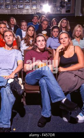 Montrant diverses émotions, un groupe d'élèves du secondaire regarder un film sur le campus à Mission Viejo, CA. Remarque Le maïs soufflé. Banque D'Images