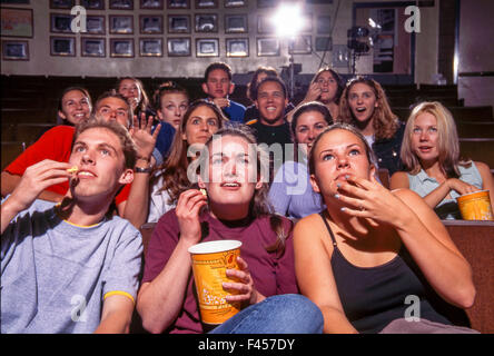 Montrant diverses émotions, un groupe d'élèves du secondaire regarder un film sur le campus à Mission Viejo, CA. Remarque Le maïs soufflé. Banque D'Images