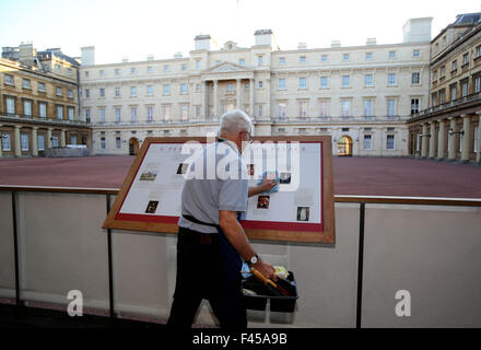 Londres, Royaume-Uni. Sep 7, 2015. Photo prise le 7 septembre 2015 montre un membre du personnel de nettoyage d'un panneau d'au palais de Buckingham à Londres, capitale de la Grande-Bretagne. Le palais de Buckingham a servi de la résidence londonienne officielle de la souverains depuis 1837 et aujourd'hui est le siège administratif du monarque. © Han Yan/Xinhua/Alamy Live News Banque D'Images