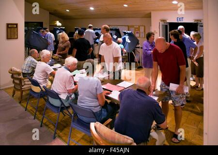 Les résidents d'un Laguna Niguel, CA, la communauté en copropriété la queue aux bureaux de scrutin à leur club house le jour de l'élection le soir. Remarque les bénévoles et des machines à voter. Banque D'Images