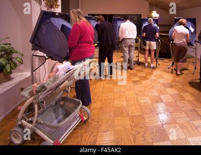 Les résidents d'un Laguna Niguel, CA, la copropriété vote communautaire au scrutin à leur club house le jour de l'élection le soir. Les machines de vote ordinateur Note et poussette de bébé. Banque D'Images