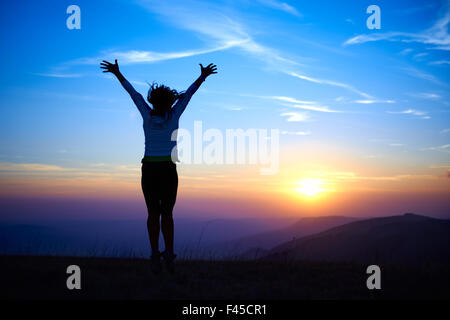 Silhouette de jeune femme saut Banque D'Images