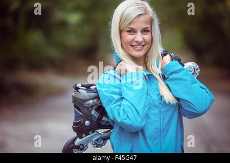 Happy blonde holding patins Banque D'Images
