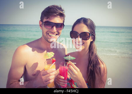 Heureux couple having cocktails on beach Banque D'Images