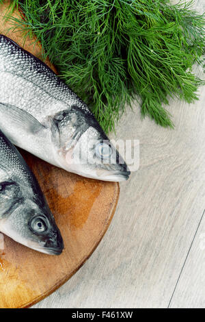 Le Bar Cru poissons sur le sol en bois Banque D'Images