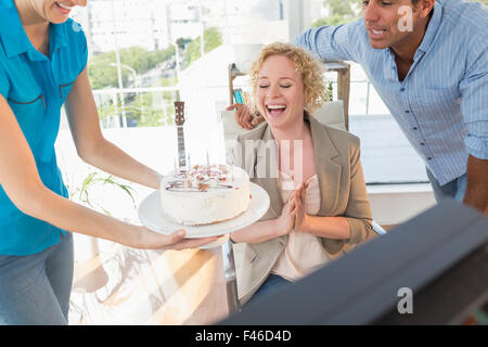 Woman blowing out candles on cake Banque D'Images