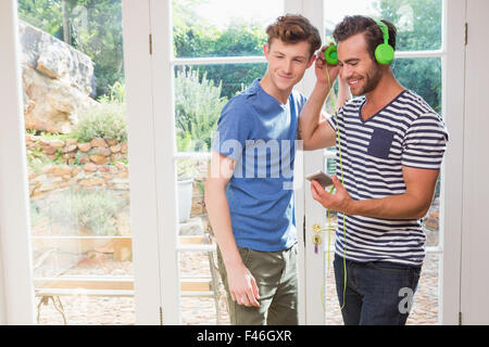 Couple homosexuel heureux d'écouter de la musique ensemble Banque D'Images
