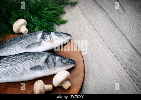 Le Bar Cru poisson sur la planche de bois Banque D'Images