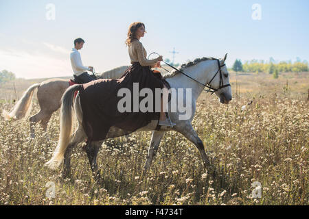 Jeune couple amoureux riding a horse Banque D'Images