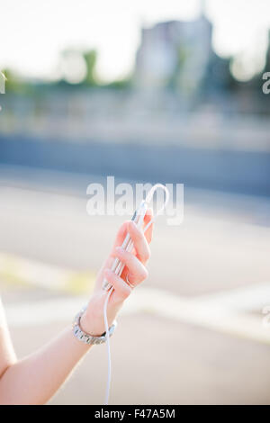 Gros plan sur la main d'un jeune beau portrait de long cheveux blond woman holding a smartphone - technologie, social network concept Banque D'Images