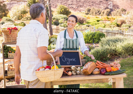 Smiling brunette agriculteur vendant des légumes Banque D'Images