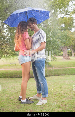 Cute couple hugging sous le parapluie Banque D'Images