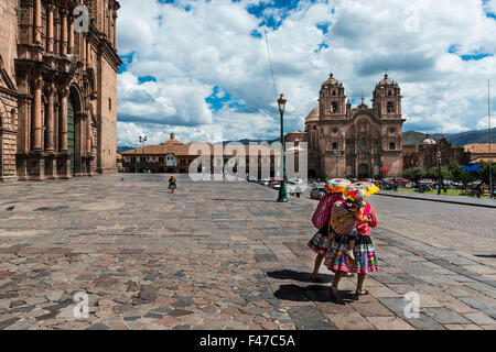 Deux femmes locales vêtu du costume traditionnel marche dans la Plaza de Armas, à Cusco, Pérou, 2013 Banque D'Images