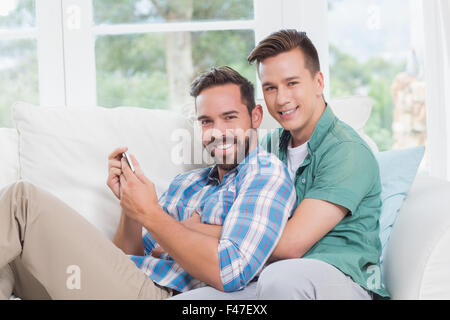 Couple Smiling men looking at smartphone Banque D'Images