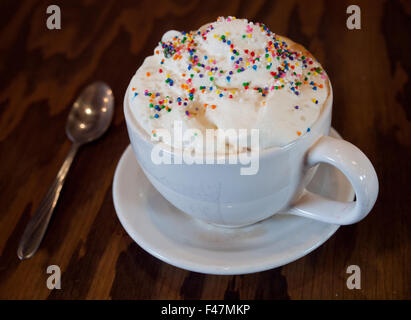 Un gâteau chaud avec latté et saupoudre de couleur crème fouettée de d'établir par Tish Café à Saskatoon, Saskatchewan, Canada. Banque D'Images