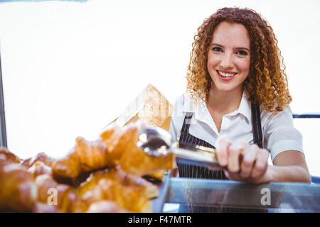 Happy pretty barista preparing pastry Banque D'Images