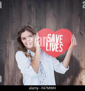 Image composite de woman holding heart card Banque D'Images