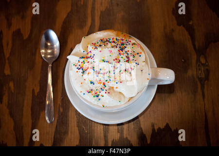 Un gâteau chaud avec latté et saupoudre de couleur crème fouettée de d'établir par Tish Café à Saskatoon, Saskatchewan, Canada. Banque D'Images