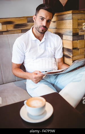 Jeune homme lisant un journal Banque D'Images