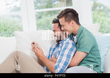 Couple homosexuel hommes looking at smartphone Banque D'Images