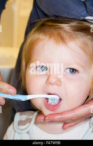 Bébé / enfant l'avoir brossé les dents de lait avec une brosse à dents / brosse à dents - par sa mère. Banque D'Images