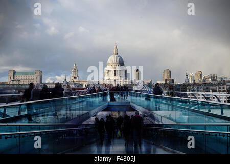 Les gens de marcher à travers le pont du millénaire à Londres avec la Cathédrale St Paul à l'arrière-plan Banque D'Images