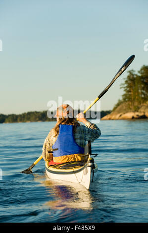 Une femme canoë, archipel de Stockholm, Suède. Banque D'Images