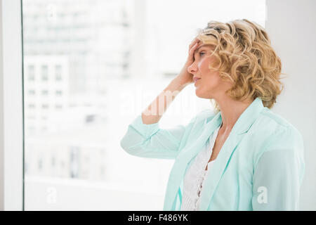 Jeune femme inquiète en regardant par la fenêtre Banque D'Images