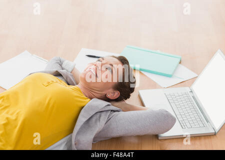 Heureux creative businesswoman relaxing sur le plancher Banque D'Images