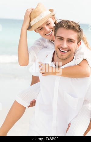 Bel homme de donner à sa petite amie à dos Banque D'Images