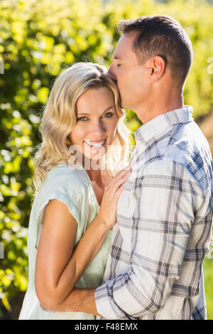 Portrait of smiling woman d'être embrassé par son homme près de grapevine Banque D'Images