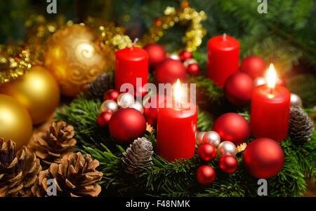 Studio shot d'une belle guirlande de noël et deux bougies rouges en feu Banque D'Images