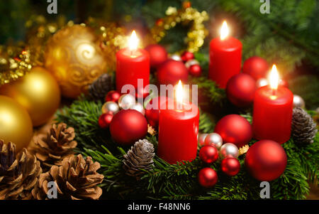 Studio shot d'une belle guirlande de noël et quatre bougies rouges en feu Banque D'Images