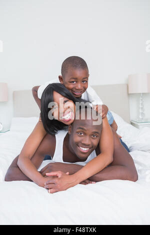 Joli couple avec son fils dans le même lit Banque D'Images