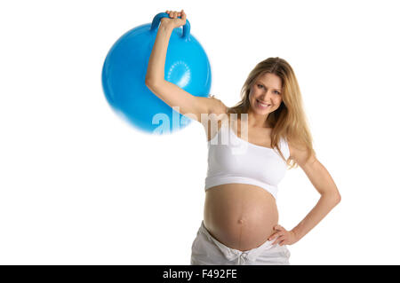 Happy pregnant woman picks up big blue ball Banque D'Images