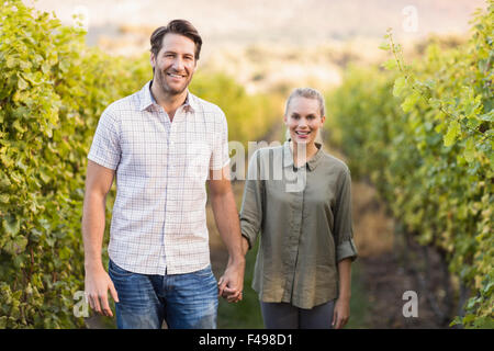 Deux jeunes vignerons heureux holding hands Banque D'Images