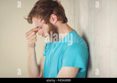 Hipster troublée leaning against wall Banque D'Images