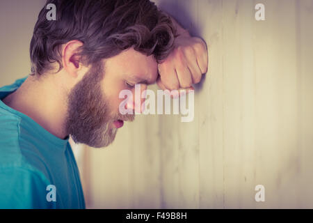 Hipster troublée leaning against wall Banque D'Images