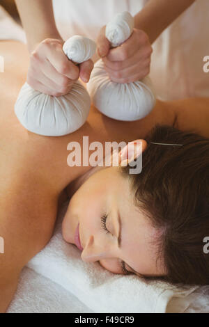 Young woman getting massage herbal compress Banque D'Images