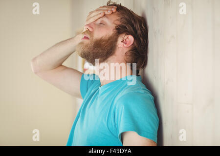 Hipster troublée leaning against wall Banque D'Images