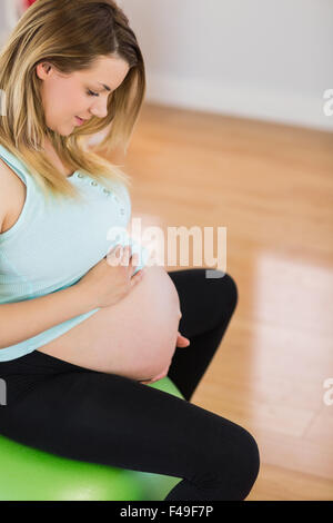 Pregnant woman sitting on exercise ball Banque D'Images