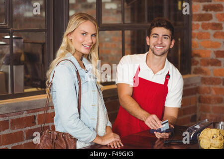 Smiling waiter glisser la carte de crédit Banque D'Images