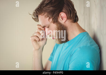 Hipster troublée leaning against wall Banque D'Images