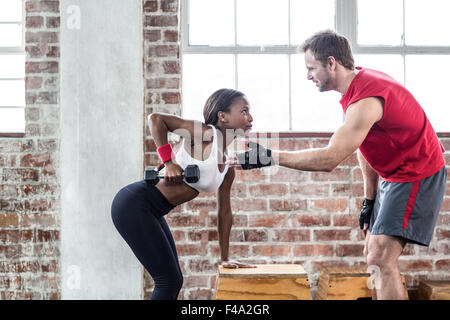 Woman lifting musculaire ciblée avec son entraîneur d'haltères Banque D'Images